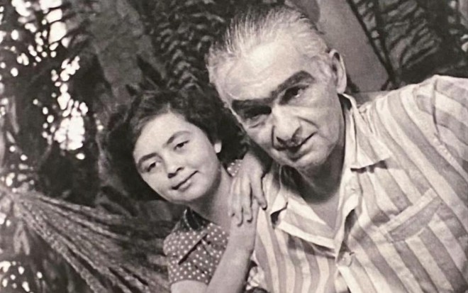 Ainda criança, Joyce Campos Lobato está apoiada no avô, Monteiro Lobato, em uma foto preto e branco