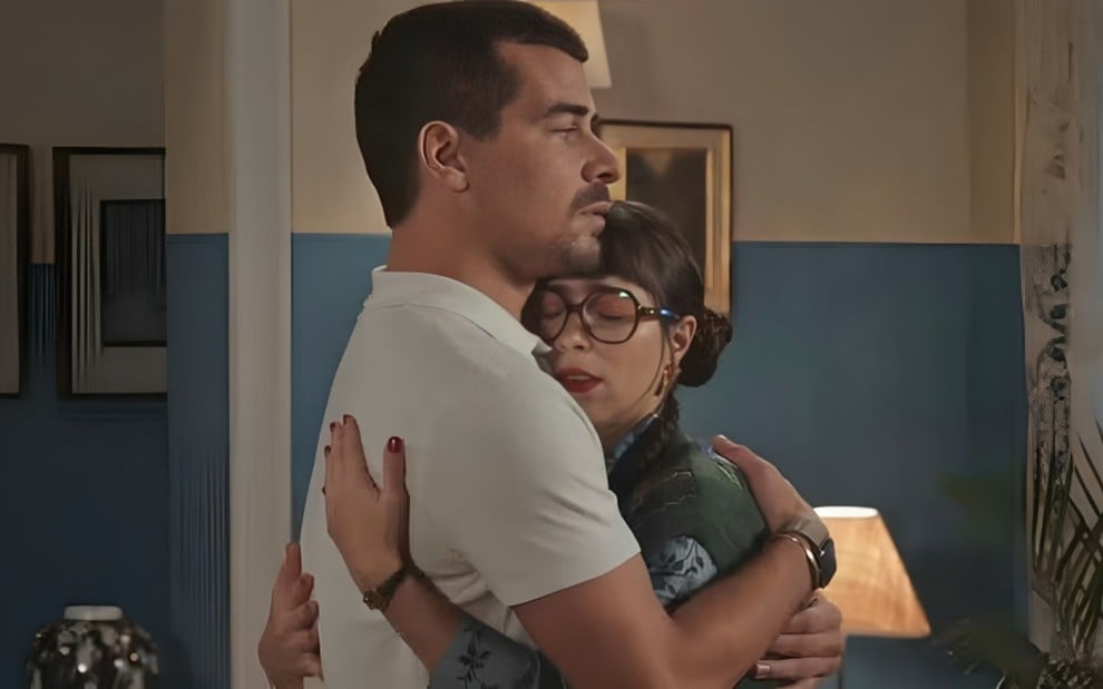 Os atores Thiago Martins e Daphne Bozaski abraçados em cena de Família É Tudo