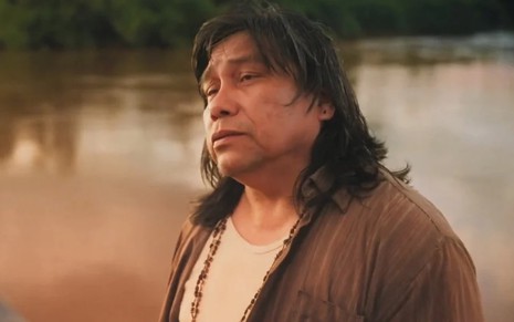 Daniel Munduruku em cena como Jurecê em Terra e Paixão, com expressão séria