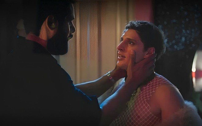 Em cena de Terra e Paixão, Amaury Lorenzo está segurando o rosto de Diego Martins