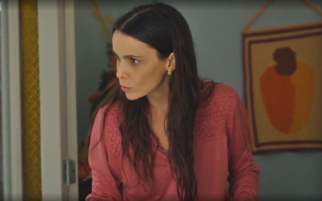 Em cena de Terra e Paixão, Débora Falabella está falando com alguém com a expressão de apreensão
