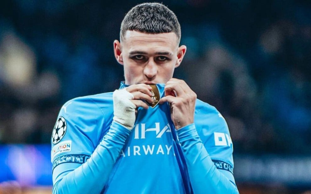 Phil Foden, do Manchester City, veste uniforme azul com detalhes em branco durante partida