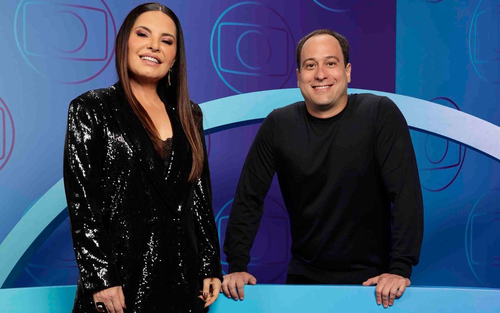Manzar Feres, principal executiva da área comercial da Globo, e Paulo Marinho, vice-presidente, no Upfront 2025; eles vestem roupas prestas