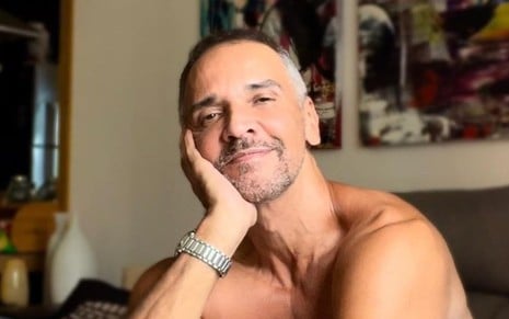 O ator Marcelo Saback em foto publicada no Instagram, com leve sorriso de boca fechada, mão no queixo, em sala de casa