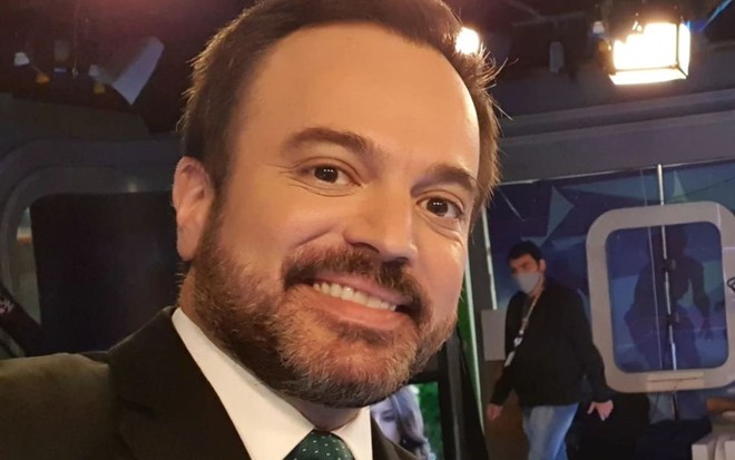 Marcelo Torres usa terno e sorri para a câmera nos bastidores do SBT Brasil