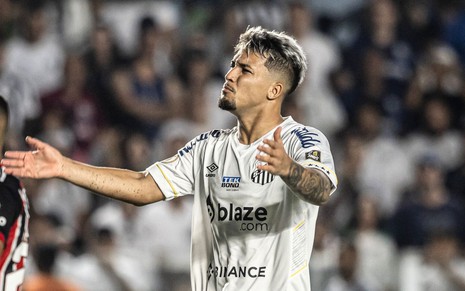 Marcos Leonardo usa uniforme branco do Santos; ele está de braços abertos em jogo na Vila Belmiro