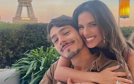 Mariana Rios abraça João Luís Diniz D'Avila pelo pescoço; ao fundo, é possível e uma vista privilegiada da Torre Eiffel, em Paris