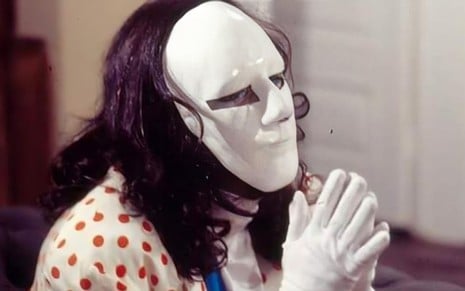 O Mascarado, personagem que fez sucesso na novela A Viagem (1994), com máscara branca no rosto, luvas brancas, mãos juntas