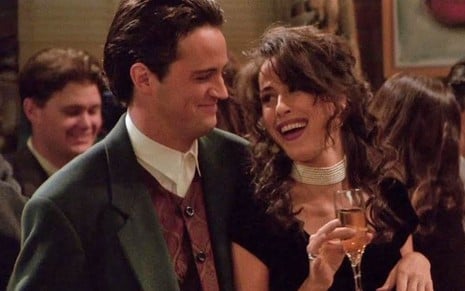 Matthew Perry e Maggie Wheeler caracterizados como Chandler e Janice em Friends, rindo juntos