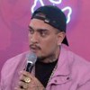 MC Binn com um casaco rosa e um microfone na mão direita no Prêmio Gshow BBB