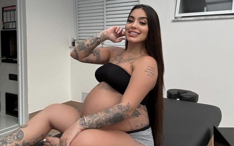 MC Mirella sorrindo e exibindo a barriga de grávida