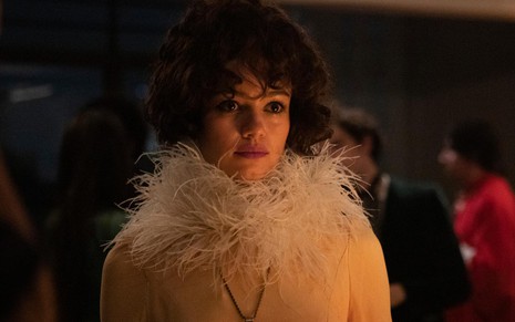 Sophie Charlotte caracterizada como Gal Costa, com expressão séria e blusa com plumas no pescoço, em cena do filme Meu Nome É Gal