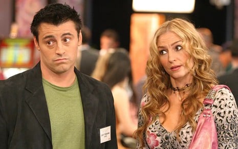 Matt LeBlanc e Drea de Matteo têm expressões desconfiadas em cena da série Joey