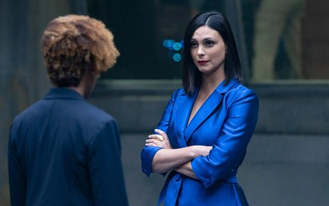 Morena Baccarin usa um terninho azul e franze o cenho em cena da série The Endgame