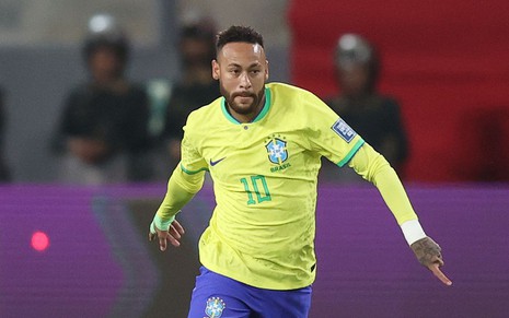 Neymar corre com a bola em jogo da Seleção Brasileira; ele usa uniforme tradicional da CBF