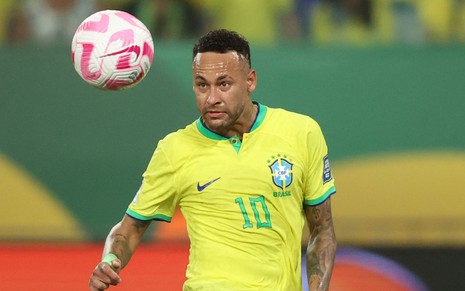 Neymar olha para a bola enquanto faz movimento para dominar a bola; ele usa a camisa tradicional da Seleção Brasileira