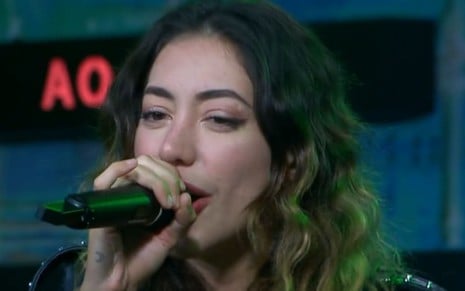 Nicole Louise segura um microfone e canta no Estrela da Casa