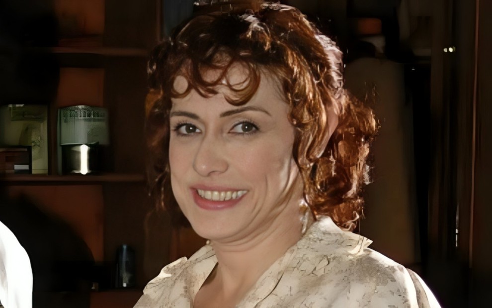 A atriz Nina de Pádua sorrindo, caracterizada como Eliete em Alma Gêmea