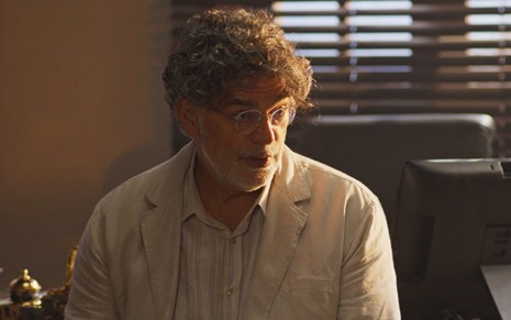 O ator Eduardo Moscovis com expressão séria em cena como Ariosto em No Rancho Fundo