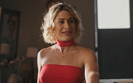 A atriz Luisa Arraes de blusa vermelha, sorrindo em cena de No Rancho Fundo