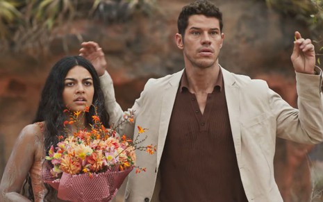 Quinota (Larissa Bocchino) segura um buquê de flores, e Marcelo Gouveia (José Loreto) coloca as mãos para o alto em cena de No Rancho Fundo
