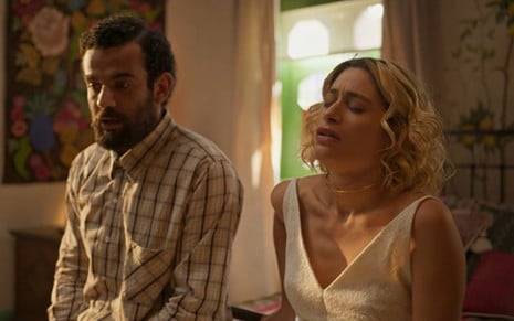 O ator Igor Fortunato, sério, sentado ao lado da atriz Luisa Arraes, de olhos fechados, em cena de No Rancho Fundo