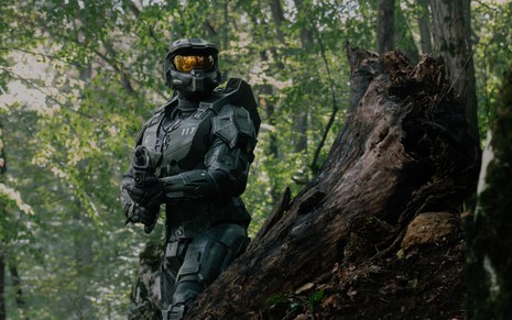Caracterizado como Master Chief, Pablo Schreiber carrega um corpo desmaiado em cena da série Halo