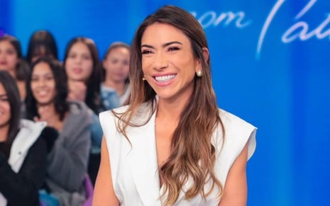 Patricia Abravanel sorri e usa um vestido branco no Programa Silvio Santos, no SBT