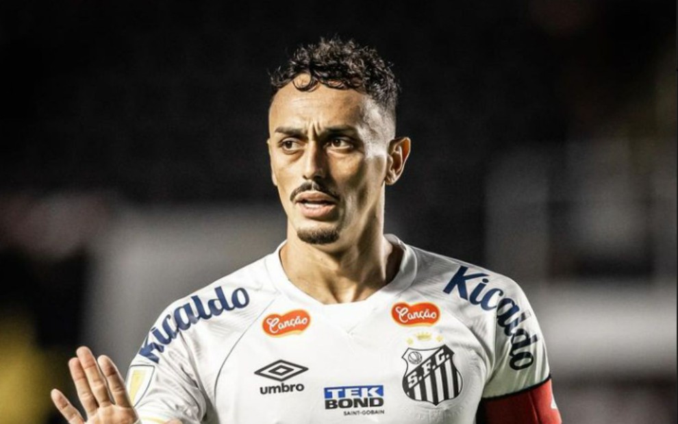 Jogador Diego Pituca, do Santos, com aparência séria durante jogo; ele usa camisa tradicional preta e branca