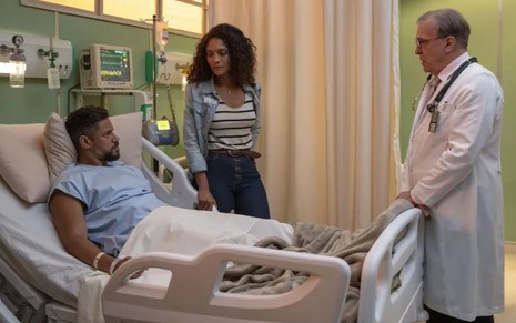 Jonatas (Paulo Lessa) está deitado na cama do hospital; Aline (Barbara Reis) aparece em pé ao lado dele em cena da novela Terra e Paixão
