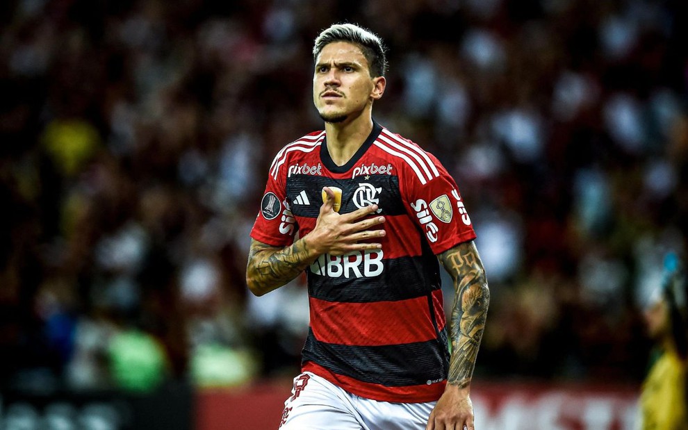 Pedro corre com a mão no peito ao comemorar gol do Flamengo; ele usa uniforme tradicional rubro-negro do clube