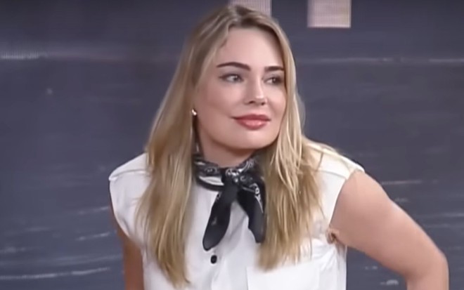 Foto de Rachel Sheherazade com uma roupa branca e um lenço preto em A Fazenda 14