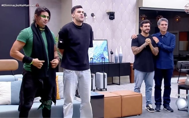 Will Rambo, Kaio Perroni, João Hadad e Fernando Sampaio estão em pé na sala da Mansão de A Grande Conquista 2