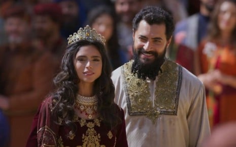Nathalia Florentino como Ester está sendo coroada ao lado de Carlo Porto, o Xerxes, em cena de A Rainha da Pérsia