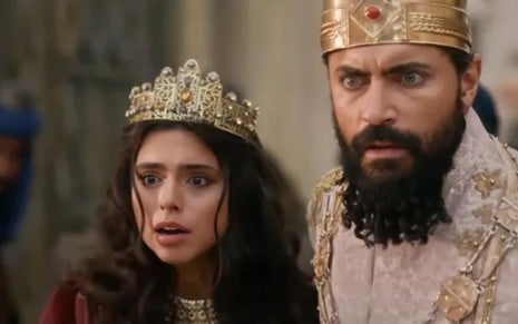 Com expressão de surpresa, Nathalia Florentino está caracterizada como Ester ao lado de Carlo Porto, o Xerxes, em cena de A Rainha da Pérsia