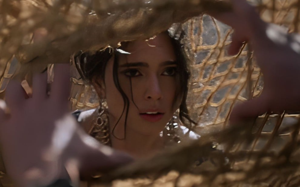 A atriz Nathalia Florentino como Ester dentro de uma rede em cena de A Rainha da Pérsia