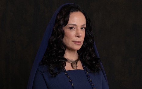Vanessa Gerbelli usa um lenço sobre os cabelos, que estão soltos, e sorri discretamente como Hagite na novela Reis