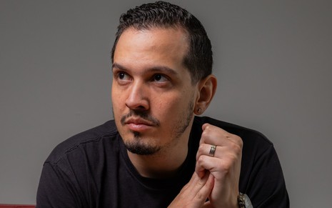O produtor Renan Lincoln posa com camiseta preta e olha para o lado