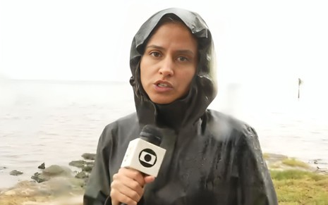 Raquel Krähenbühl usa uma capa de chuva no Bom Dia Brasil, na Globo