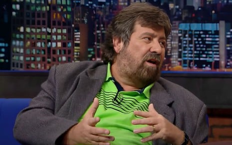 Roberto Manzoni gesticula e usa polo verde com blazer cinza