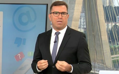 Rodrigo Bocardi com expressão séria e usando terno no cenário do Bom Dia São Paulo