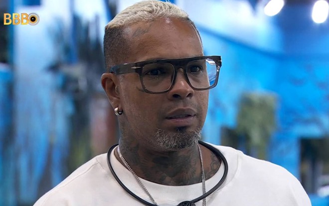 Foto de Rodriguinho no BBB 24; ele usa óculos de grau e camiseta branca