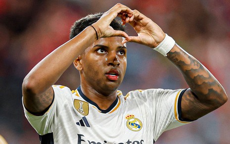 Rodrygo comemora gol fazendo sinal do coração com as duas mãos; ele usa uniforme branco do Real Madrid