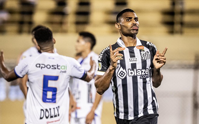 Joaquim Henrique ergue os dedos indicadores, fazendo o número 1 com as duas mãos