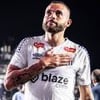 Guilherme, do Santos, veste uniforme branco com detalhes pretos durante partida da equipe