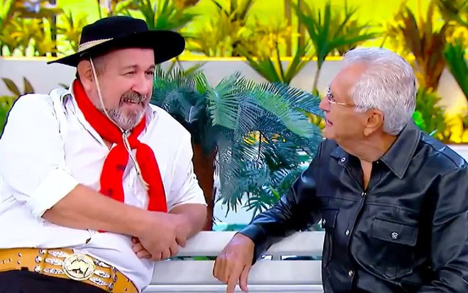 Beto Gabriel como Tibúrcio sentado no banco de A Praça É Nossa com Carlos Alberto de Nóbrega