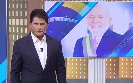 Cesar Filho está diante de uma TV com a imagem do presidente Luiz Inácio Lula da Silva