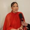 Virginia Fonseca, de vermelho, dá entrevista diante de um microfone com o nome de Leo Dias