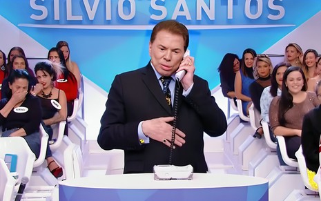 Silvio Santos fala ao telefone no cenário do Programa Silvio Santos