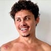 Silvero Pereira está sem camisa e sorri; ele olha para um ponto fixo a direita em foto publicada nas redes sociais